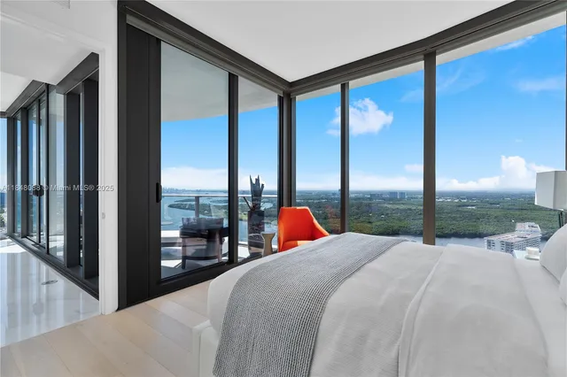 a bed sitting in front of a window with a balcony