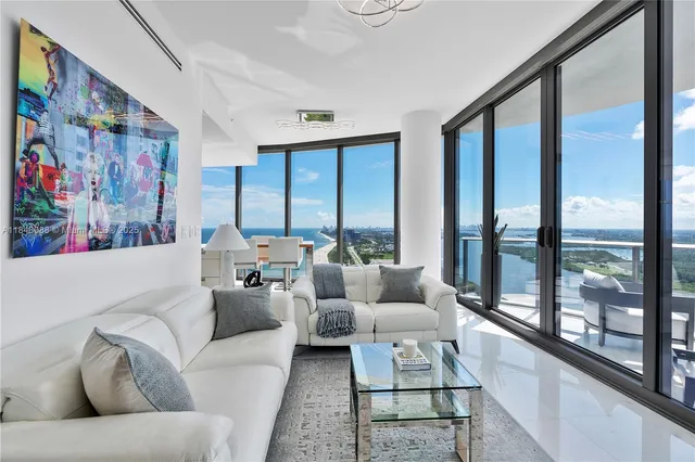 a living room with furniture and large windows