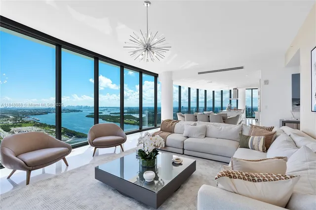 a living room with furniture a large window and a chandelier