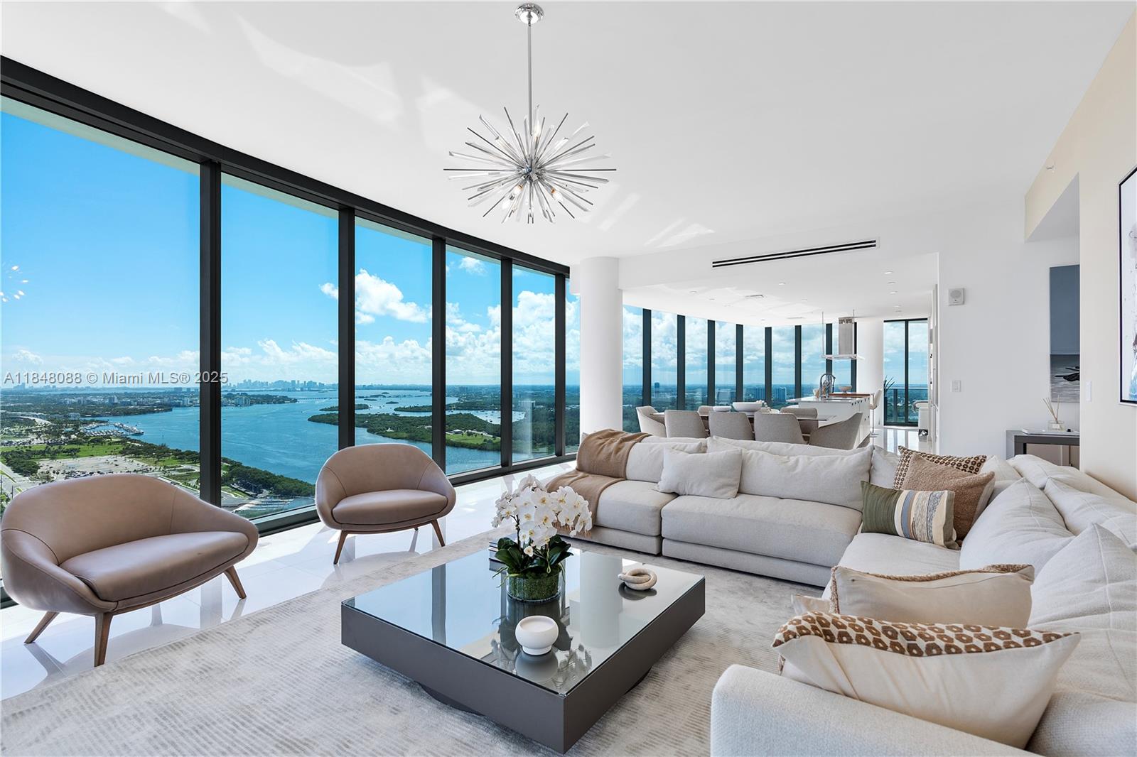 15701 Collins Avenue, Unit 3605 Sunny Isles Beach, FL 33160 - Photo 9 of 46 a living room with furniture a large window and a chandelier