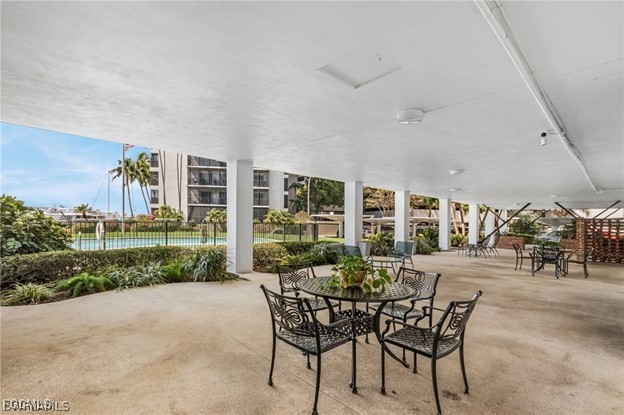 2350 West First Street, Unit 603 Fort Myers, FL 33901 - Photo 14 of 17 a view of a patio with table and chairs near a yard
