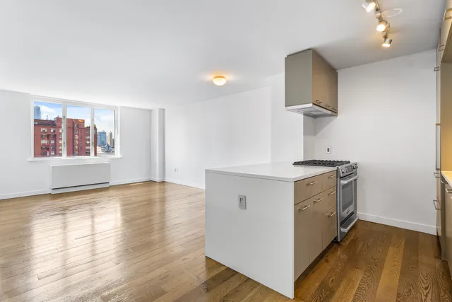 a kitchen with a stove and a white wooden cabinets