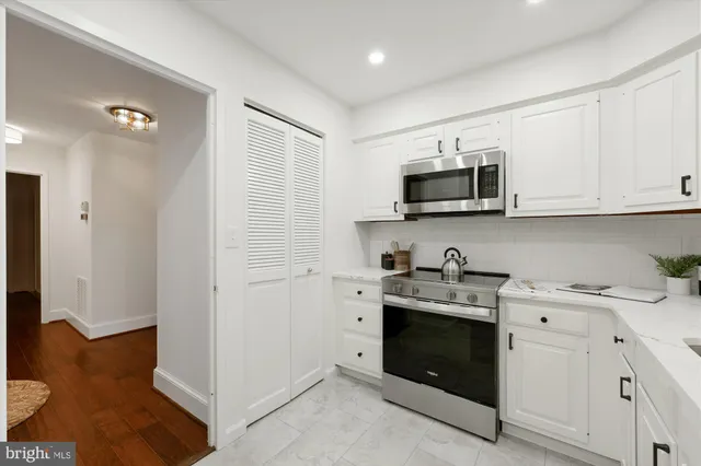 a view of cabinets a sink and a stove in a kitchen