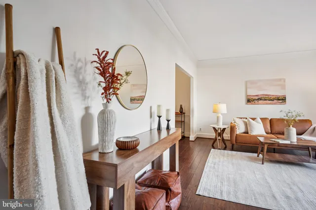 a living room with furniture a rug a clock and a window