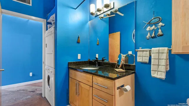 a bedroom with a bed and a lamp on the dresser