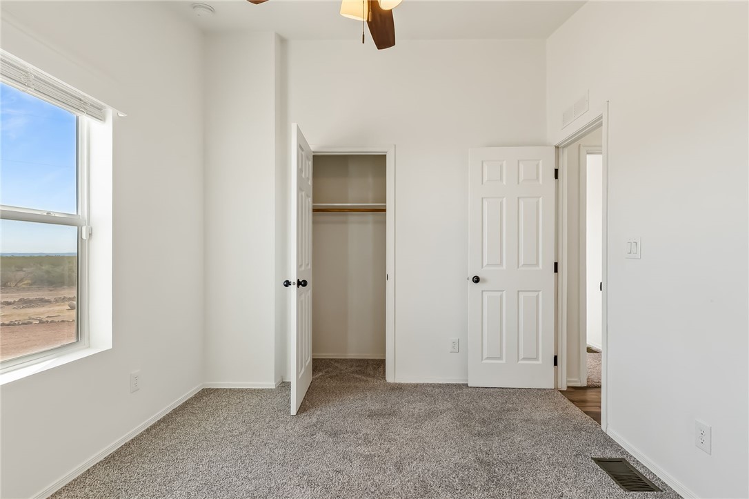 3534 Eloy Road Golden Valley, AZ 86413 - Photo 24 of 58 Unfurnished bedroom with carpet, a closet, and ceiling fan