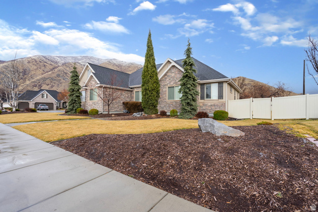 557 South 1470th Street East Springville, UT 84663 - Photo 35 of 46 View of front facade with stone siding, a mountain view, a gate, and roof with shingles