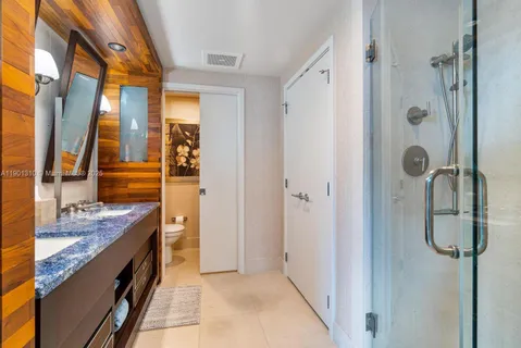 a bathroom with a granite countertop shower a sink and vanity