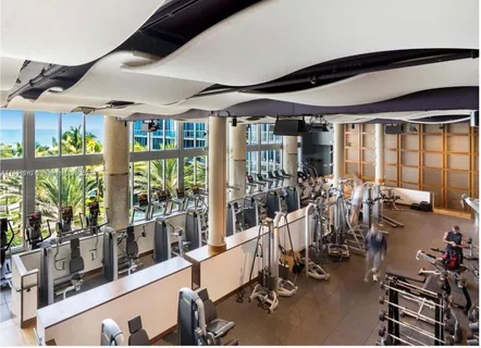a room with gym equipment and large windows
