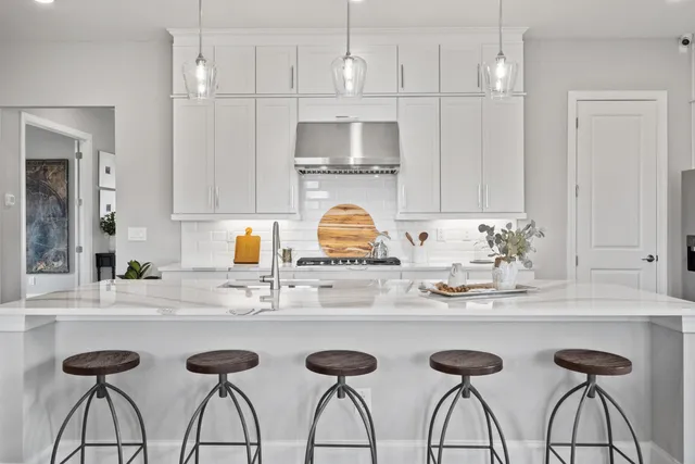 a kitchen with stainless steel appliances granite countertop a sink and white cabinets