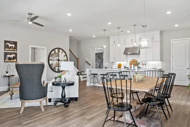 a view of a dining room with furniture a kitchen and chandelier