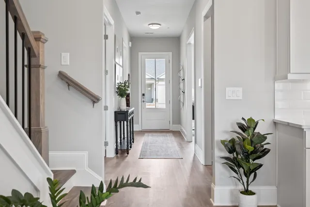 a view of a hallway with wooden floor and glass door