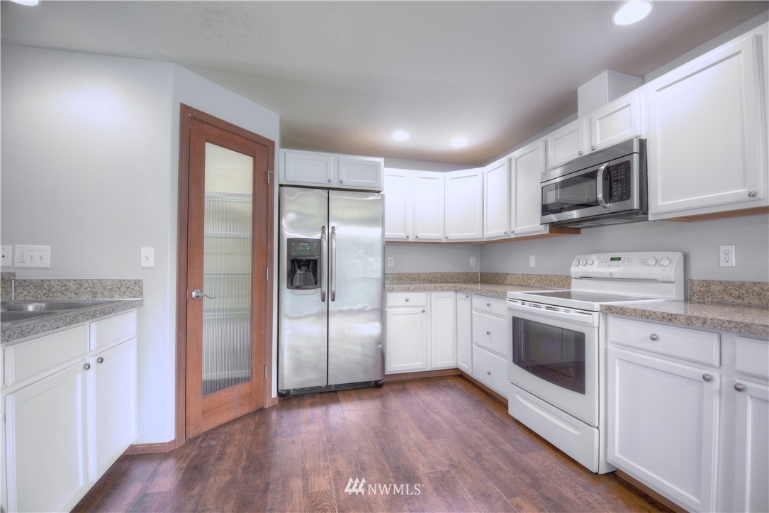 15440 Runyon Road Southeast Rainier, WA 98576 - Photo 8 of 39 a kitchen with stainless steel appliances granite countertop a stove a sink and a refrigerator