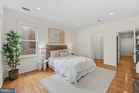 a bedroom with a large bed and a wooden floor