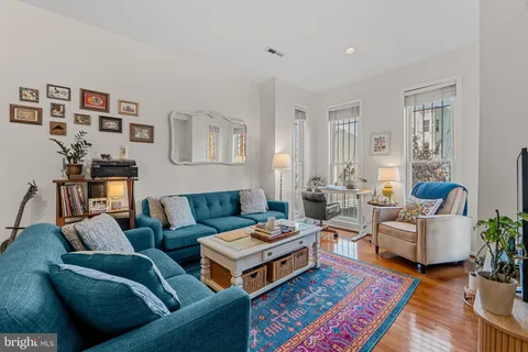 a living room with furniture and a wooden floor