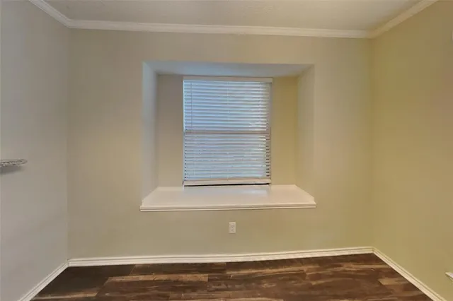 a view of a small space with wooden floor and a window