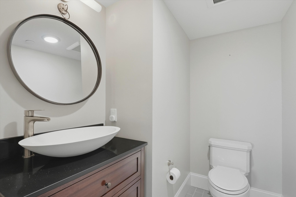 151 High Street, Unit 3B Newburyport, MA 01950 - Photo 16 of 39 a bathroom with a toilet a sink and a mirror