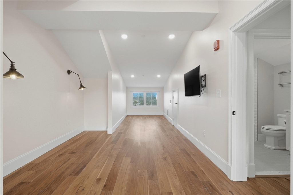 151 High Street, Unit 3B Newburyport, MA 01950 - Photo 25 of 39 a view of a hallway with wooden floor and a bathroom