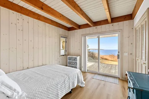 a bedroom with a bed and a large window with balcony view