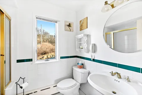 a bathroom with a toilet a sink and a mirror