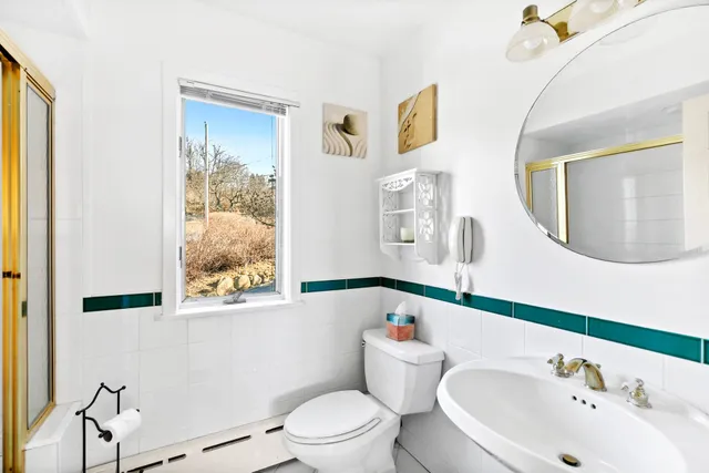 a bathroom with a toilet a sink and a mirror
