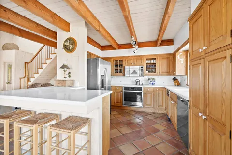 a large white kitchen with a stove a sink and a refrigerator
