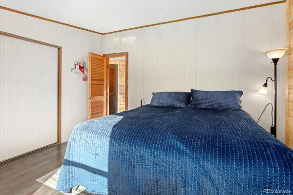 a bedroom with a bed and wooden floor