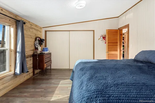 a bedroom with a bed and wooden floor