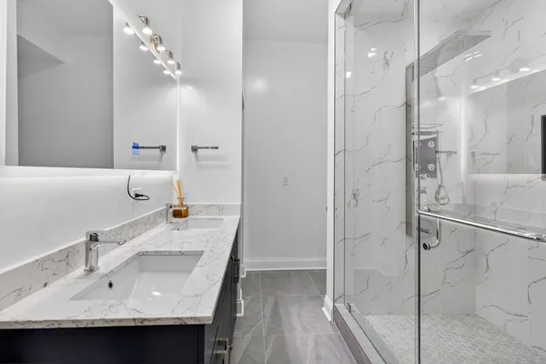 a bathroom with a granite countertop sink mirror and shower