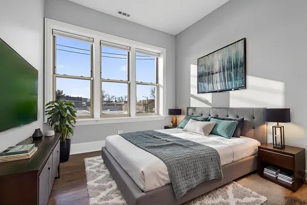 an empty room with wooden floor & windows