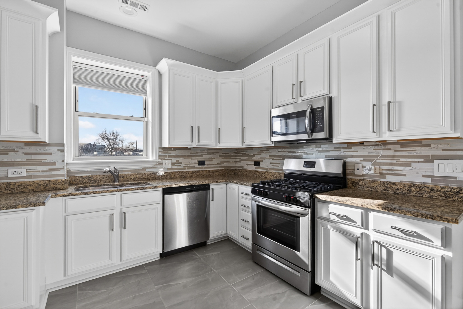 4646 South Prairie Avenue, Unit 2S Chicago, IL 60653 - Photo 19 of 32 a kitchen with granite countertop white cabinets and white stainless steel appliances