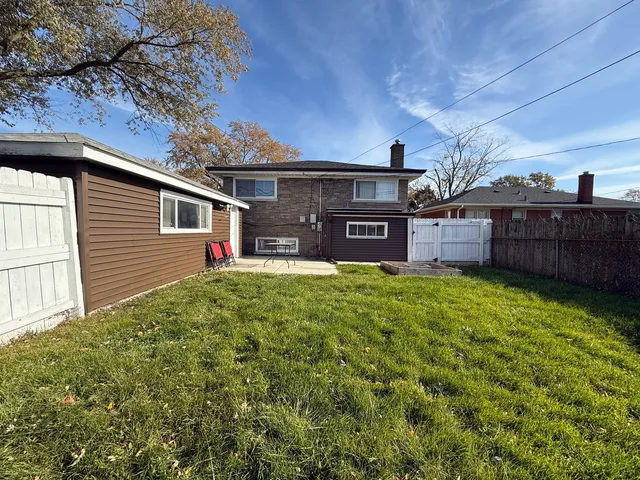 a view of a house with a backyard and a tree