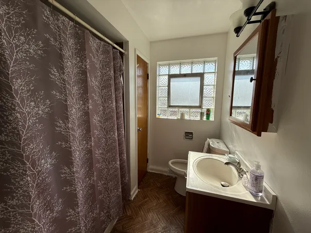 a bathroom with a sink toilet and mirror
