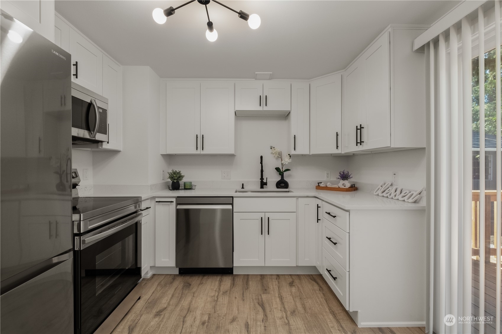 11610 Tower Road Southwest Lakewood, WA 98498 - Photo 12 of 35 a kitchen with stainless steel appliances granite countertop white cabinets granite counter tops and a hard wood floors