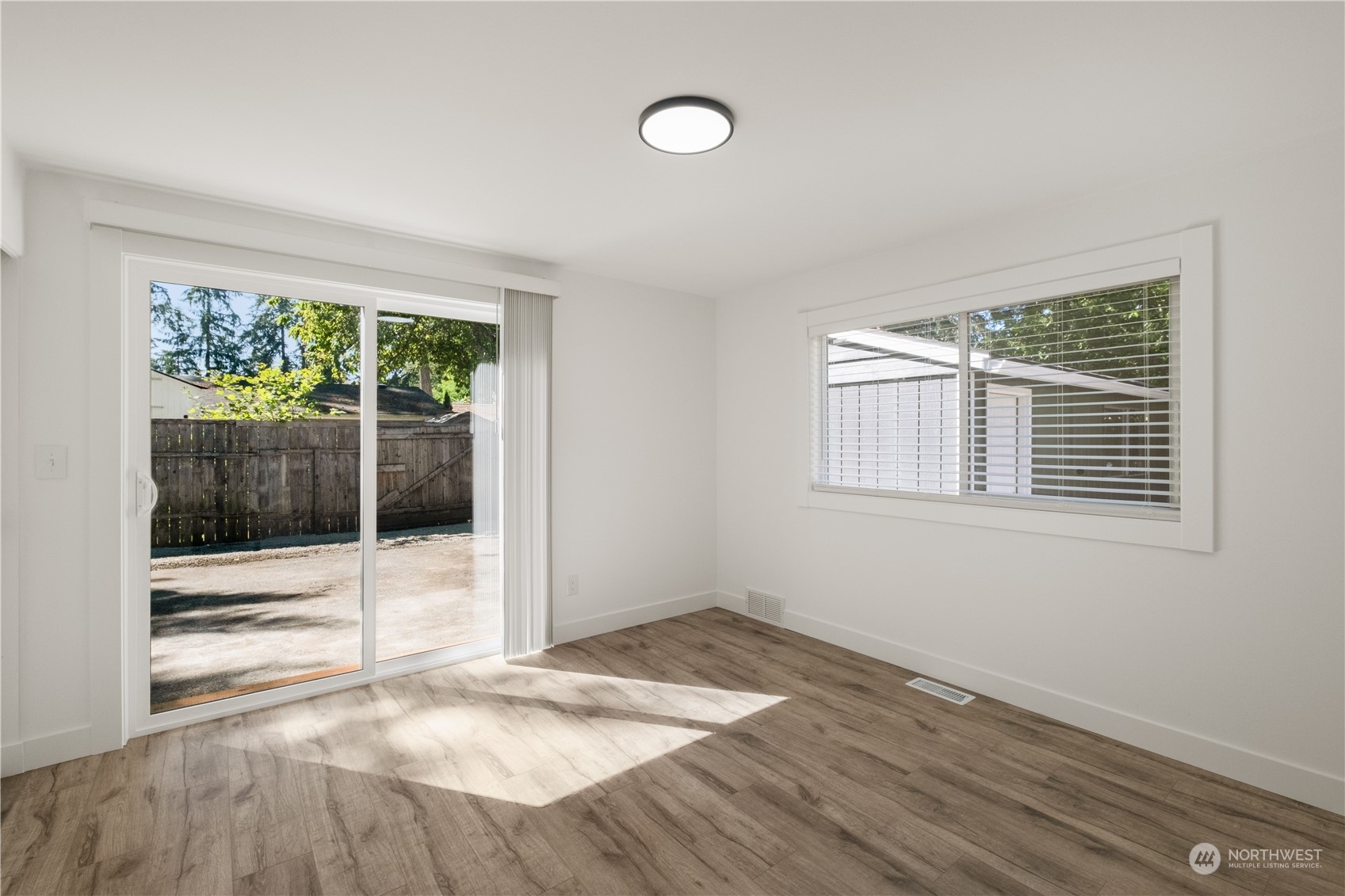 11610 Tower Road Southwest Lakewood, WA 98498 - Photo 16 of 35 a view of an empty room with wooden floor and a window