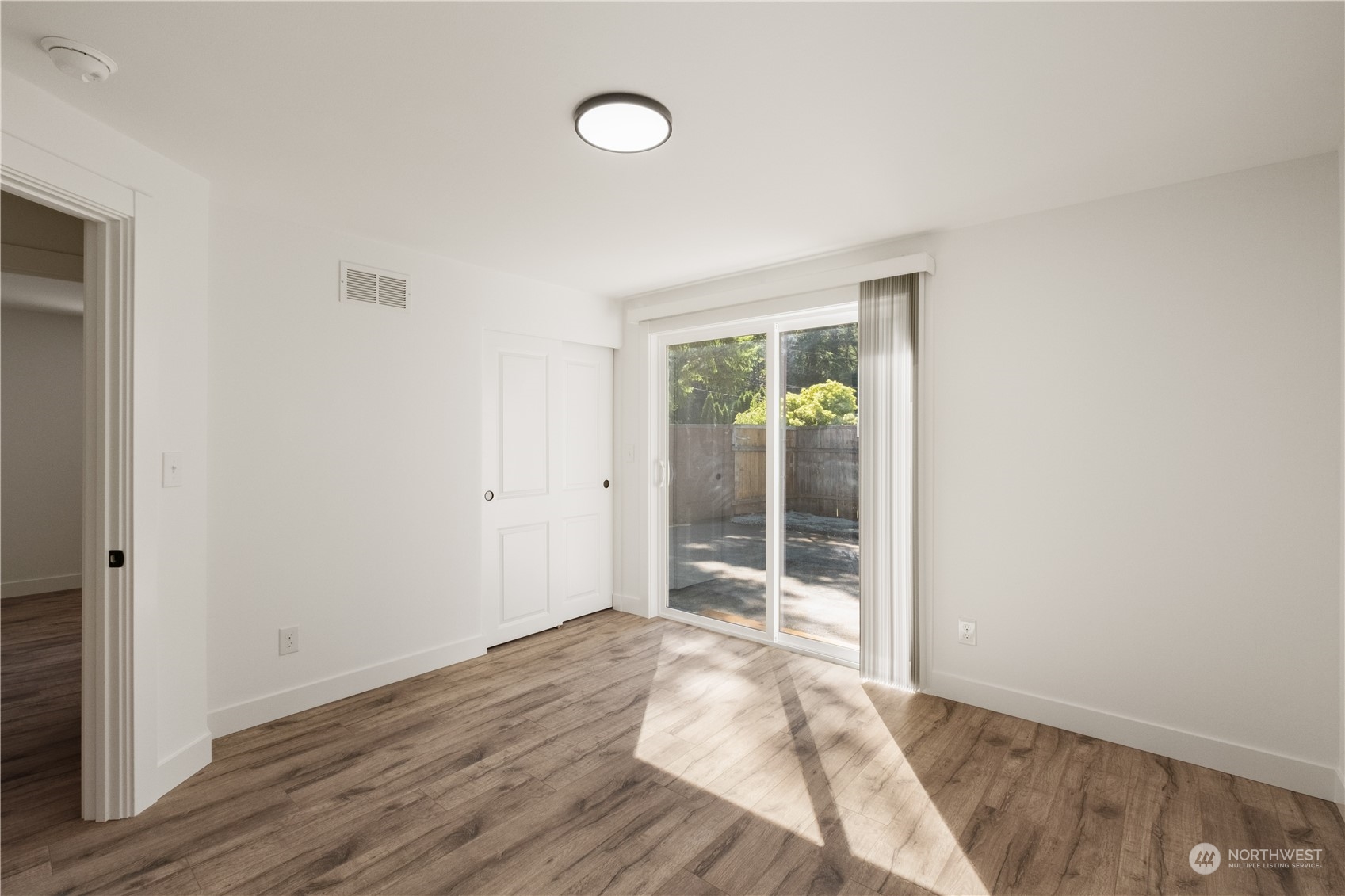 11610 Tower Road Southwest Lakewood, WA 98498 - Photo 17 of 35 an empty room with wooden floor and windows