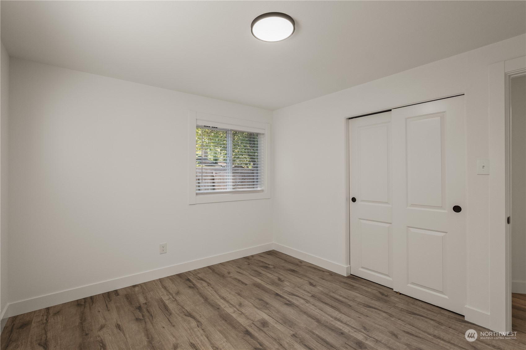 11610 Tower Road Southwest Lakewood, WA 98498 - Photo 19 of 35 an empty room with wooden floor and windows
