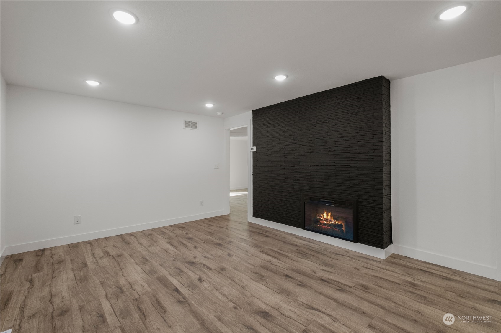 11610 Tower Road Southwest Lakewood, WA 98498 - Photo 5 of 35 a view of an empty room with wooden floor and a fireplace