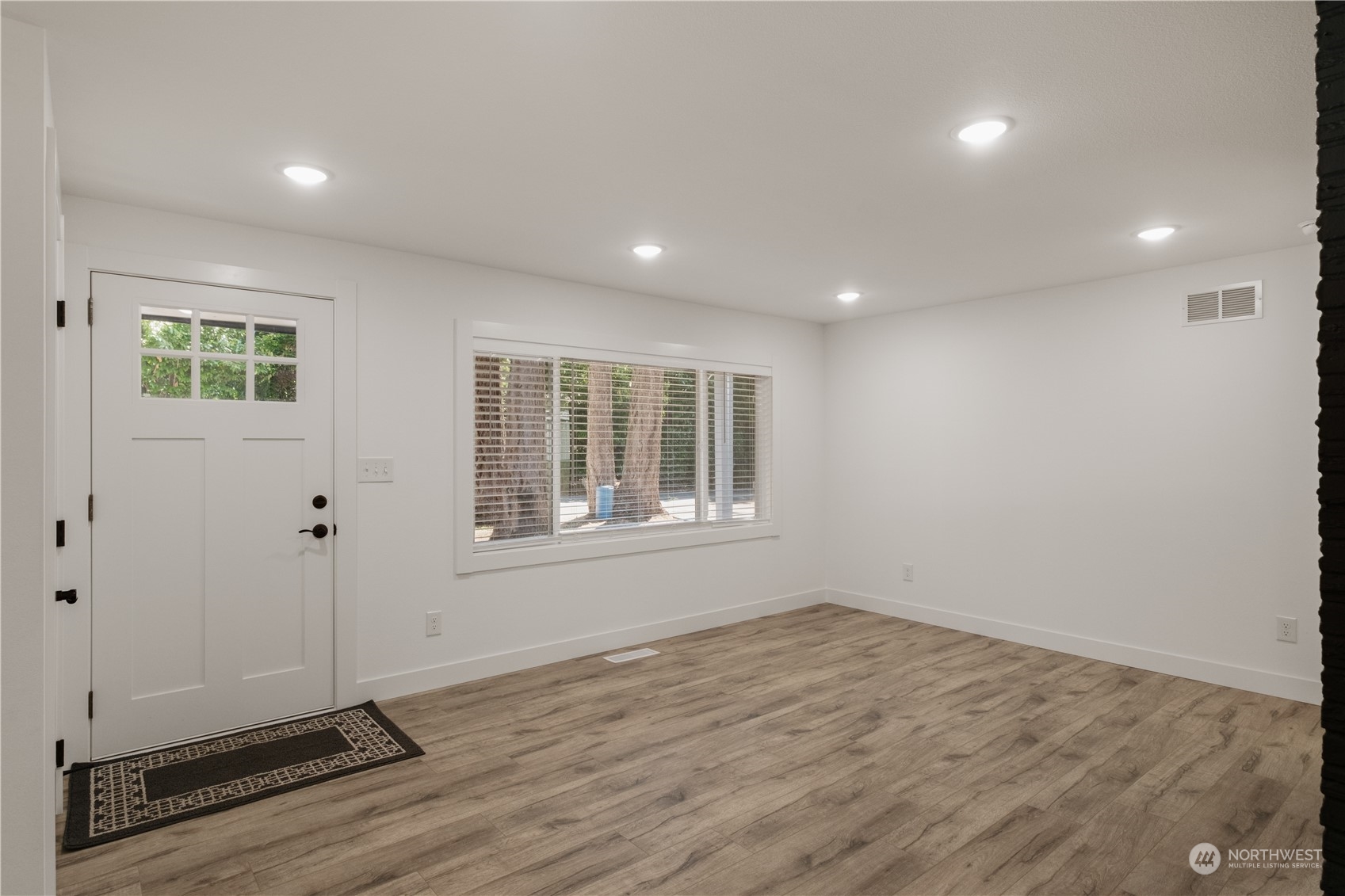 11610 Tower Road Southwest Lakewood, WA 98498 - Photo 7 of 35 an empty room with wooden floor and windows