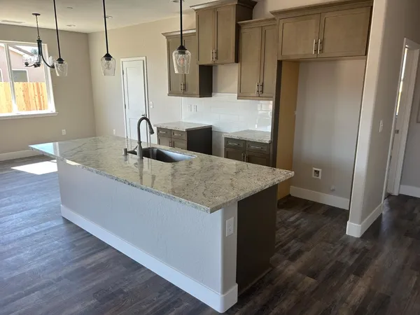 a kitchen with a sink a refrigerator and wooden floor
