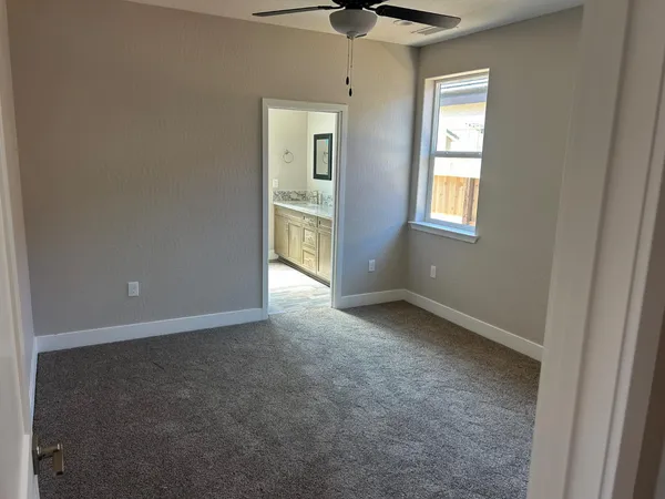 an empty room that has a window and a kitchen