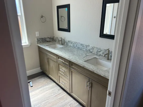 a bathroom with a granite countertop sink and a mirror
