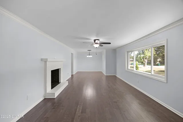an empty room with windows fireplace and a sink