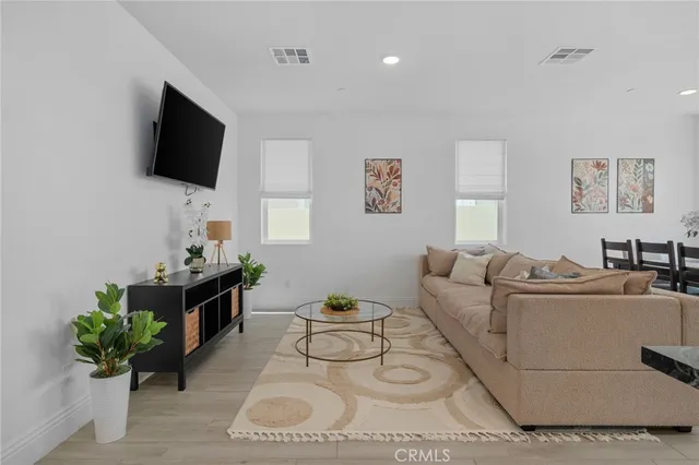 a living room with furniture a flat screen tv and a potted plant