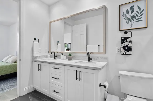 a en suite bathroom with a double vanity sink and a mirror