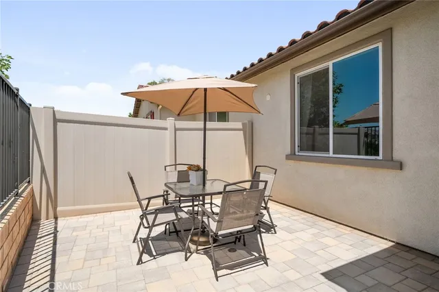 a view of a patio with table and chairs under an umbrella