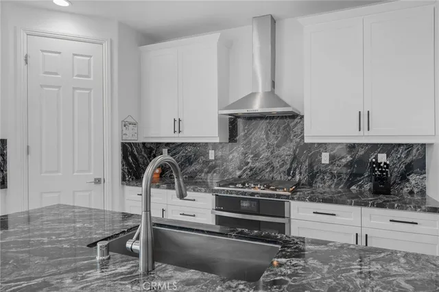 a kitchen with a stove and white cabinets