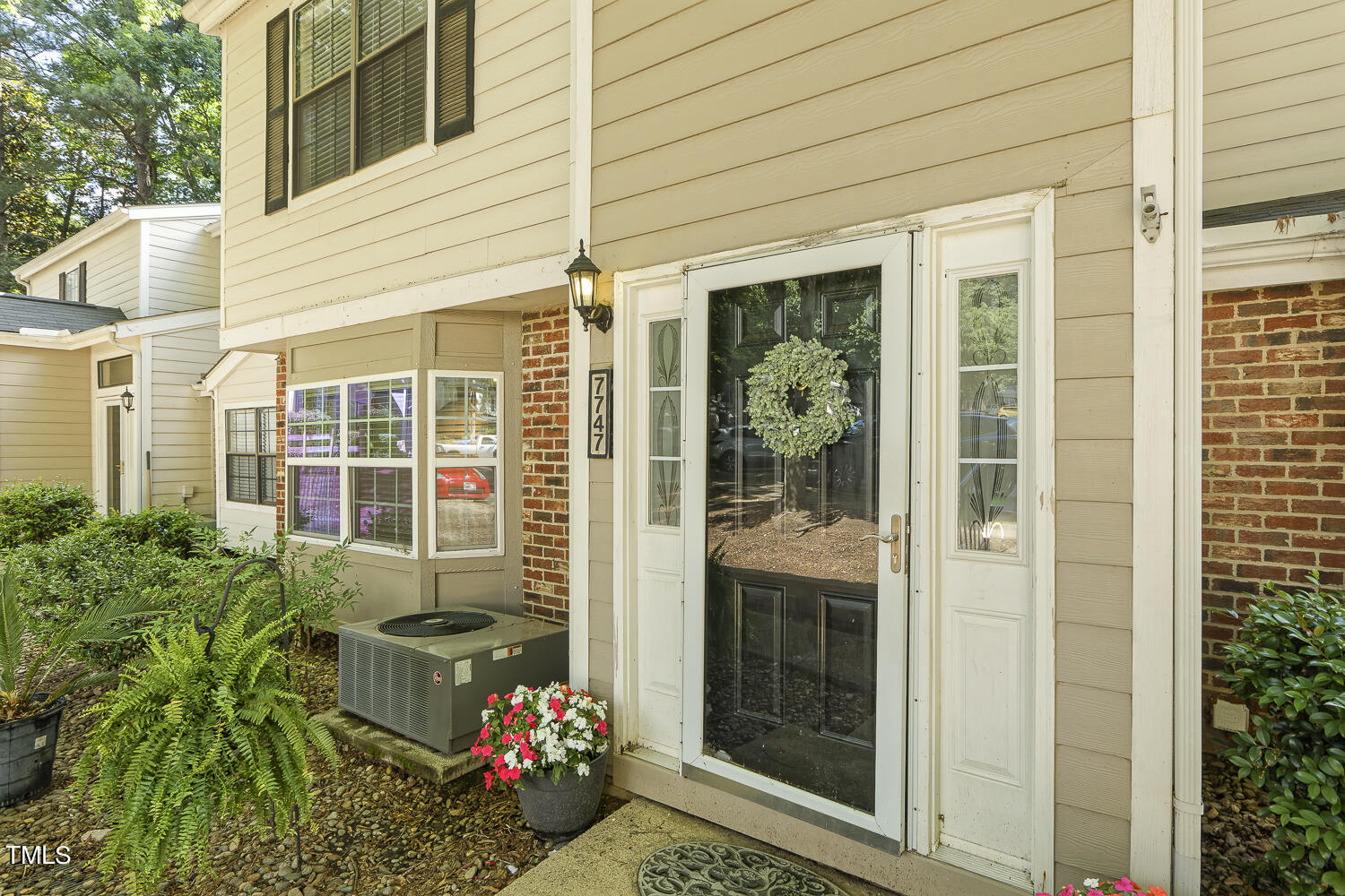 7747 Falcon Rest Circle Raleigh, NC 27615 - Photo 4 of 36 a front view of a house with a potted plant and floor to ceiling windows and potted plants