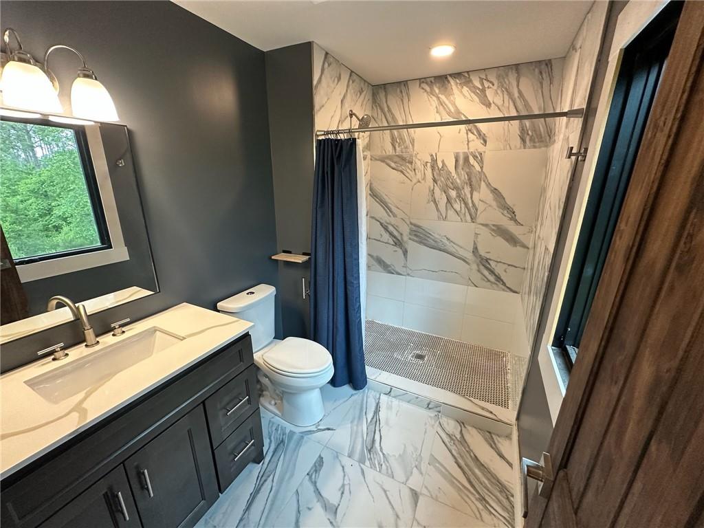 1001 Bailey Road Rome, GA 30161 - Photo 19 of 44 a bathroom with a sink a toilet a mirror and shower