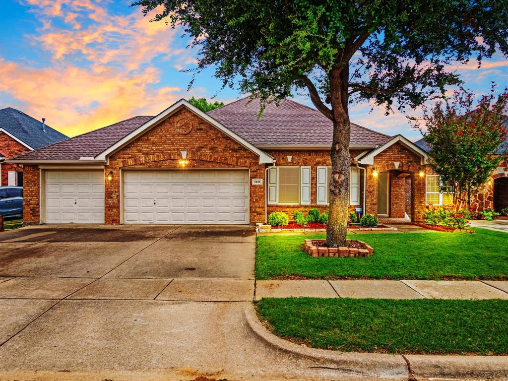 5440 Lavaca Road Grand Prairie, TX 75052 - Photo 1 of 22 Brick exterior with a shingled roof, featuring a two-car garage, established front yard landscaping, and a concrete driveway